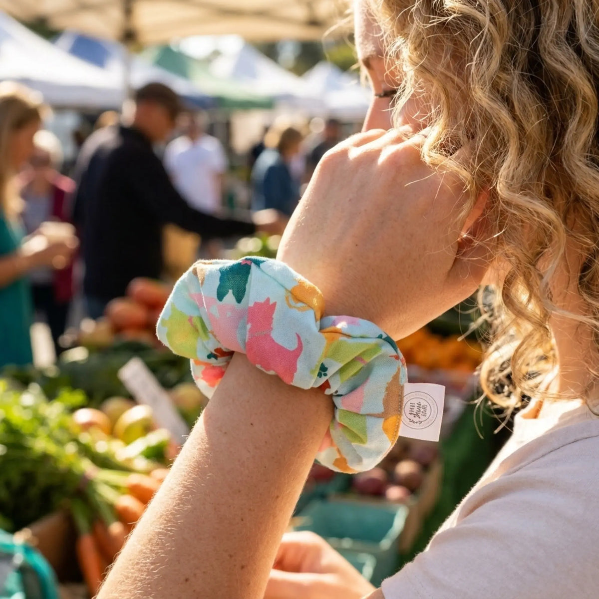 A woman wearing a scrunchie on her wrist in a crowded environment.