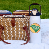 SCBA 57oz Water Bottle beside picnic basket on grass promoting South Carolina Beekeeper Association