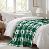 Bed with green and white checkered blanket and white pillows in a bright bedroom.
