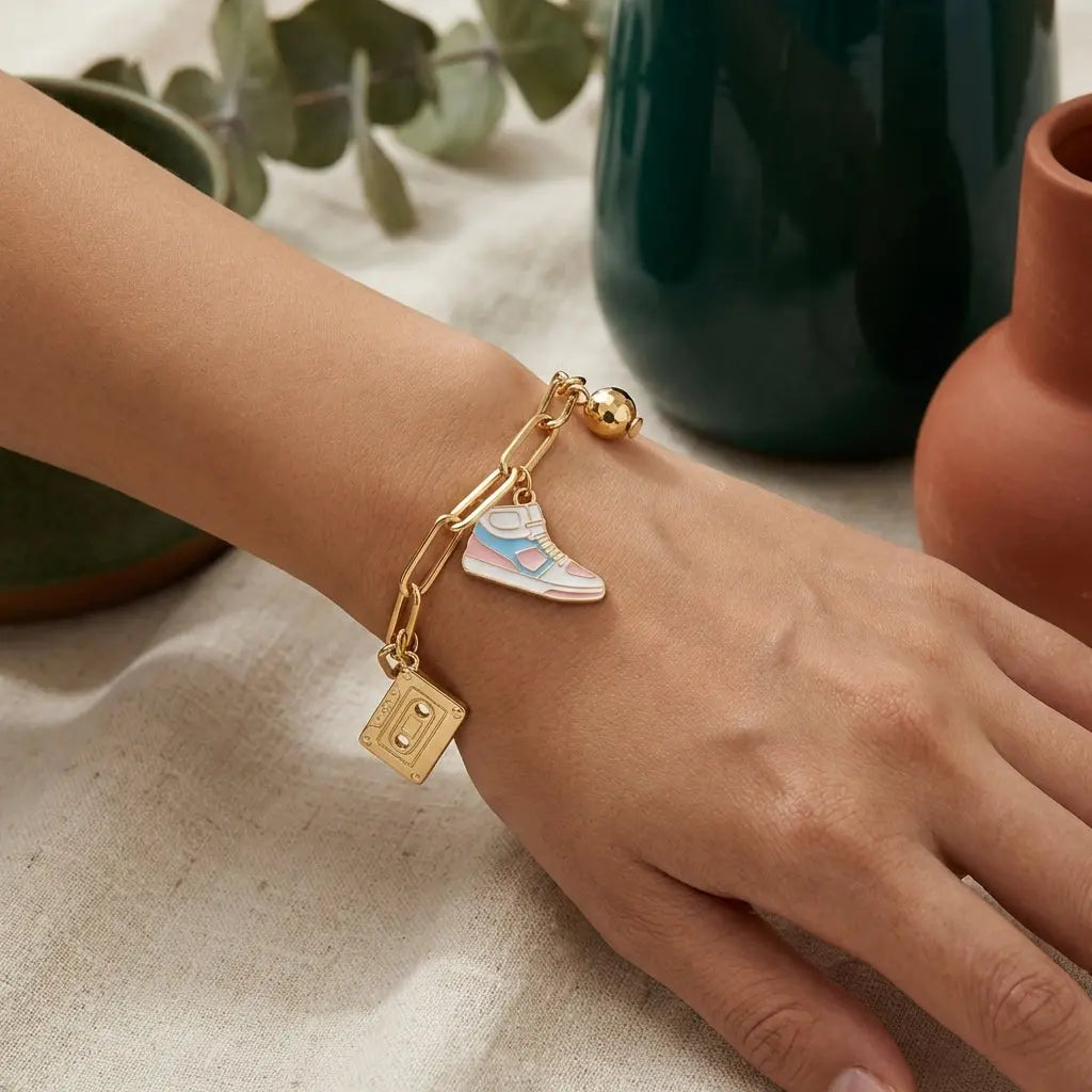 Gold sneaker charm from Winks Design Studio, LLC featuring a detailed, shiny sneaker design for jewelry or accessories.