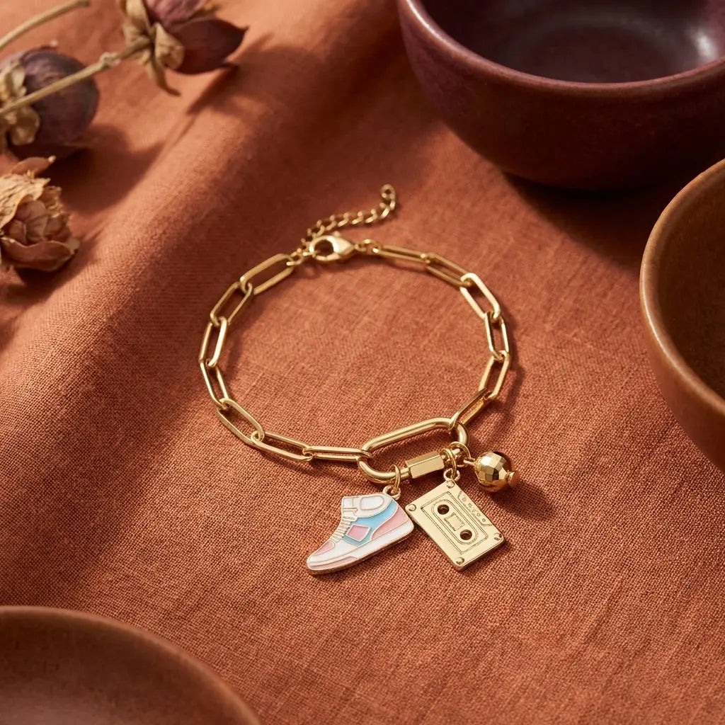 Gold sneaker charm from Winks Design Studio, LLC featuring a detailed, shiny sneaker-shaped jewelry accessory.