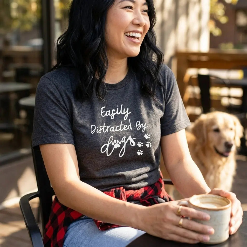 Winks Design Studio, LLC Easily Distracted By Dogs T-shirt showing a casual fit with playful text design on front.
