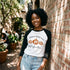 White and black raglan tee with a "Fall Breeze, Crunchy Leaves & Pumpkins Please" graphic and three orange pumpkins