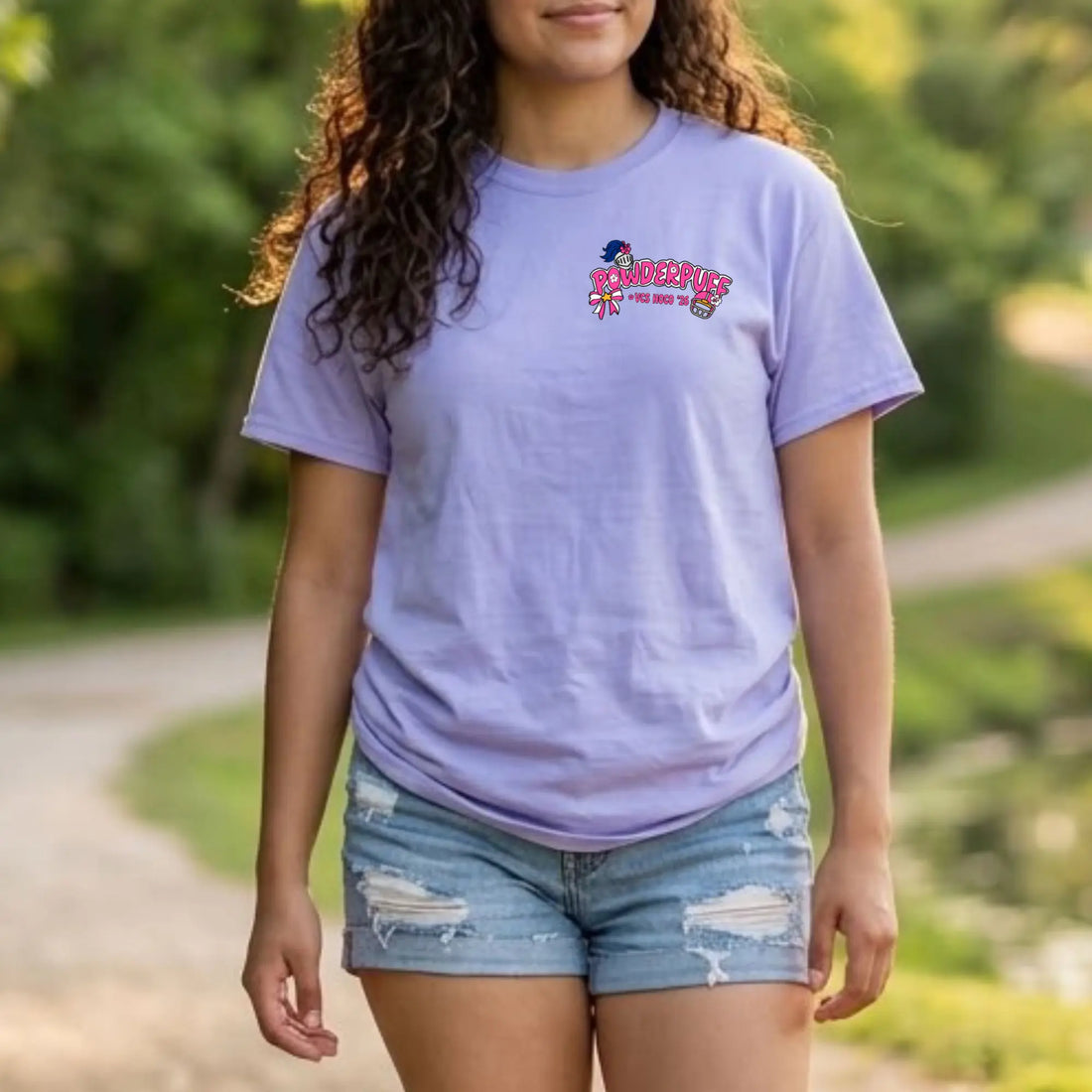 A woman wearing a light lavender-purple t-shirt with a colorful &