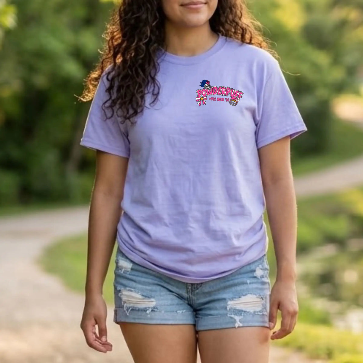 A woman wearing a light lavender-purple t-shirt with a colorful &