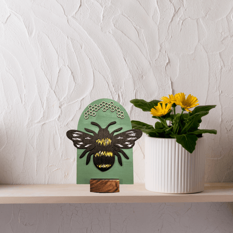 Handcrafted Bee Shelf Sign with Potted Yellow Flowers on a White Shelf