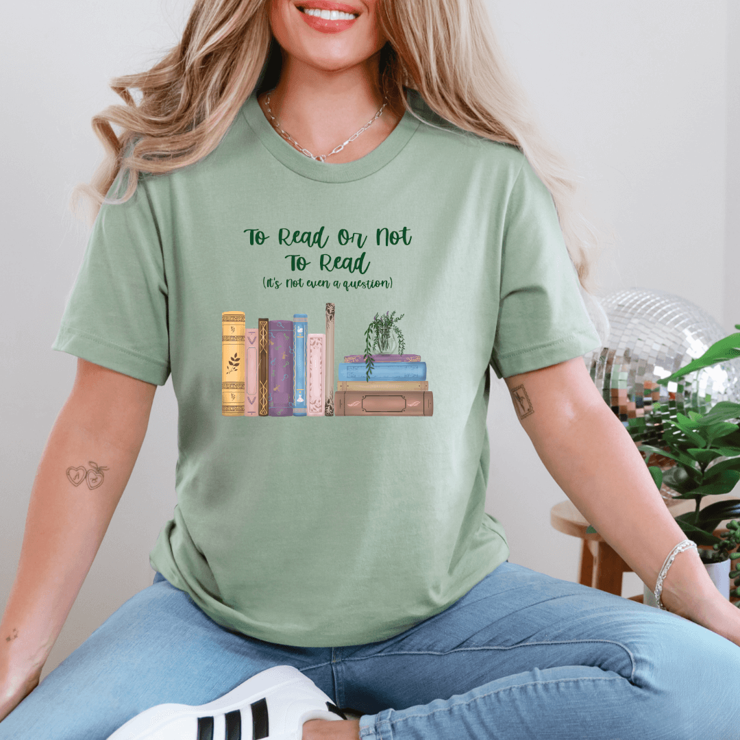 Woman wearing green "To Read Or Not To Read" T-shirt with whimsical book stack design, perfect for book lovers.