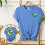 Blue SCBA short sleeve t-shirt featuring South Carolina Beekeeper Association logo, displayed on a wooden hanger with green plants.