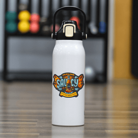 "NC Hot Sauce Contest 57oz Water Bottle with 'Feeling Saucy' design displayed indoors"