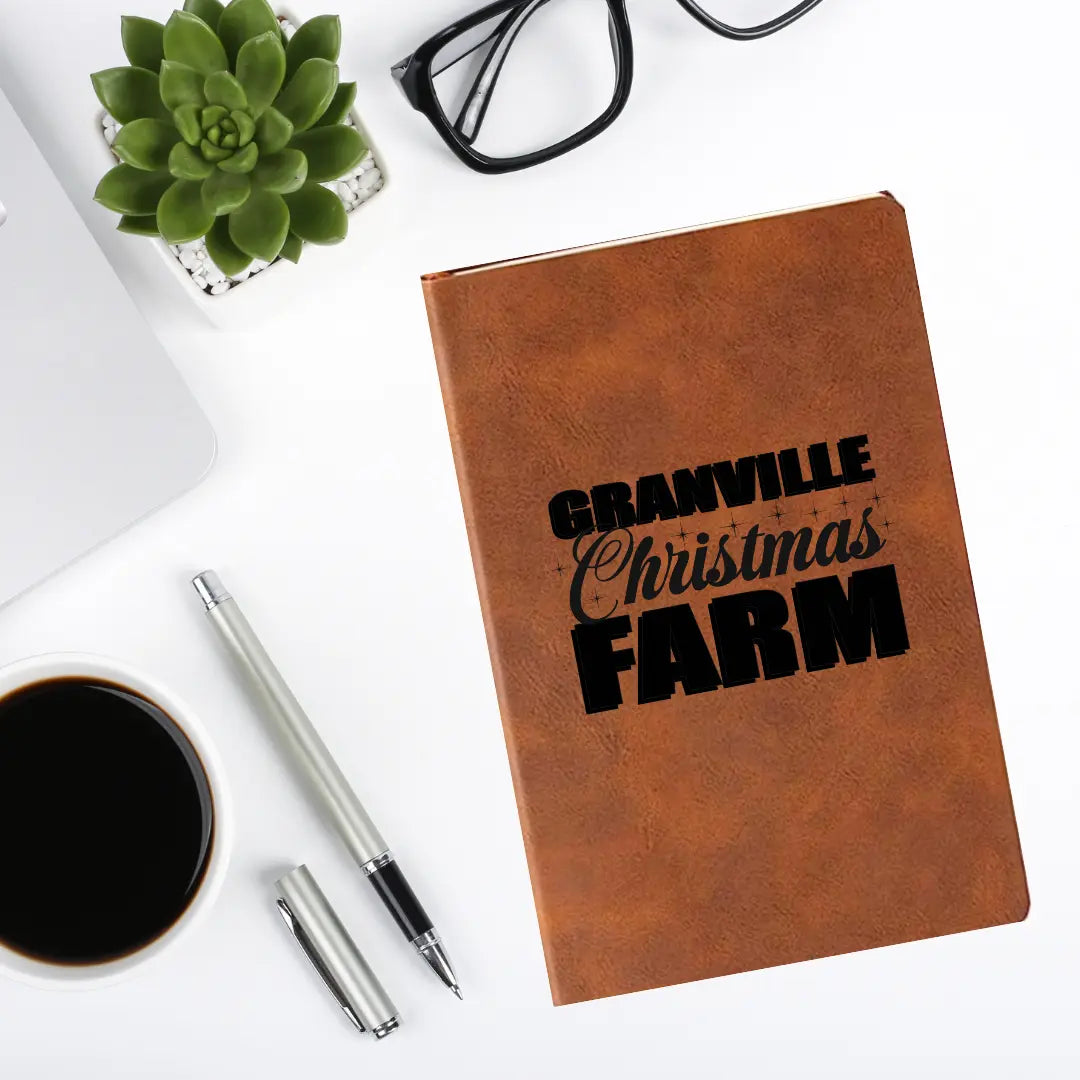 Granville Christmas Farm leather journal by Winks Design Studio, LLC, featuring a rustic farm scene on the cover.