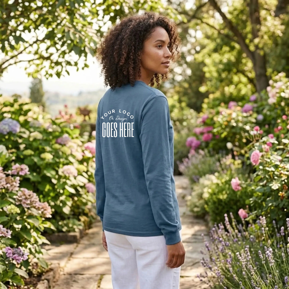 Back view of a slate blue custom long sleeve t-shirt with a white "Your Logo or Design Goes Here" upper back placeholder print