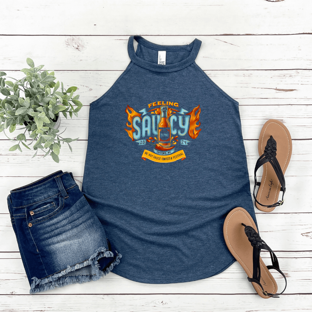 NC Hot Sauce Contest & Festival halter tank with "Feeling Saucy" design, paired with denim shorts and sandals on a white background.