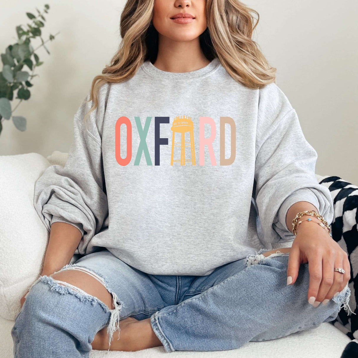 Color Blocked Oxford Water Tower Crewneck with multicolored design, worn by a woman sitting comfortably in casual attire.