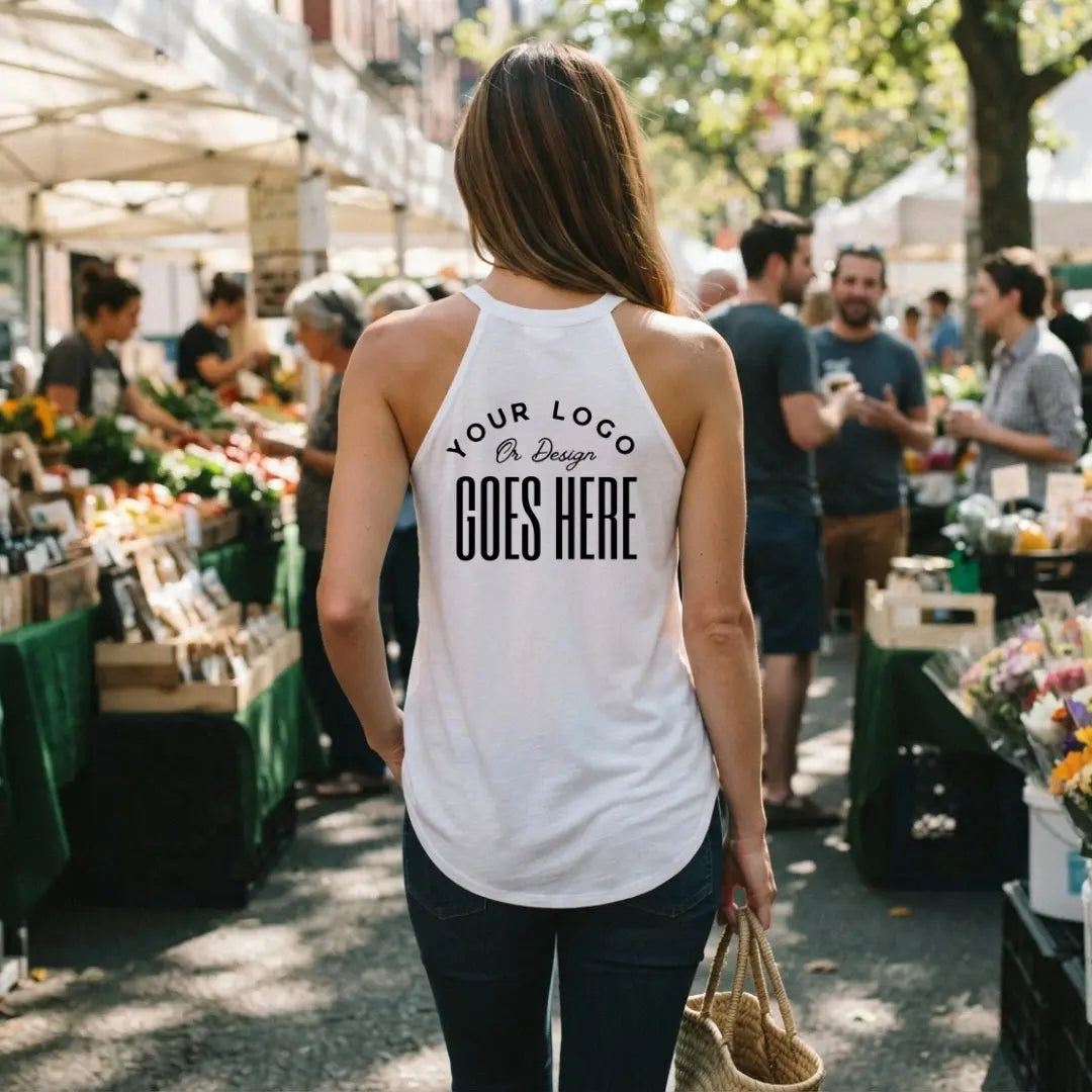 Back view of a woman in a white custom high neck tank top walking through an outdoor farmers market