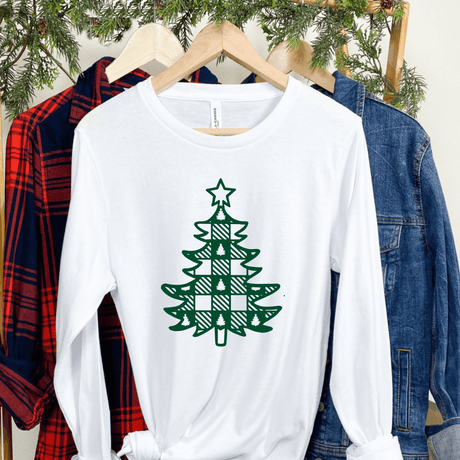 White long sleeve shirt with plaid Christmas tree design hanging between flannel and denim jackets.