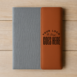 Two-tone gray and brown notebook with customizable text on a wooden surface