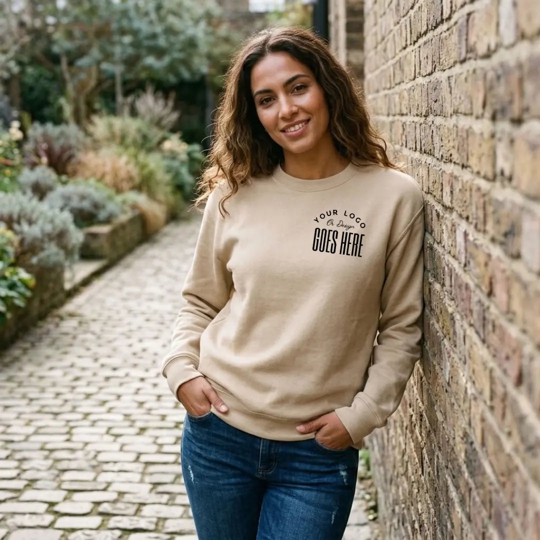 Tan custom crewneck sweatshirt with a black "Your Logo or Design Goes Here" left chest placeholder print