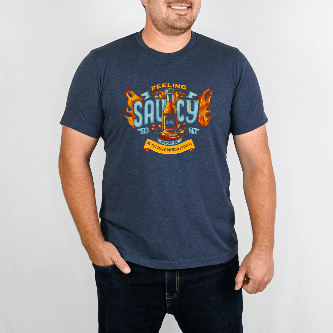 Man wearing NC Hot Sauce Contest & Festival T-shirt with bold "Feeling Saucy" design in navy blue.