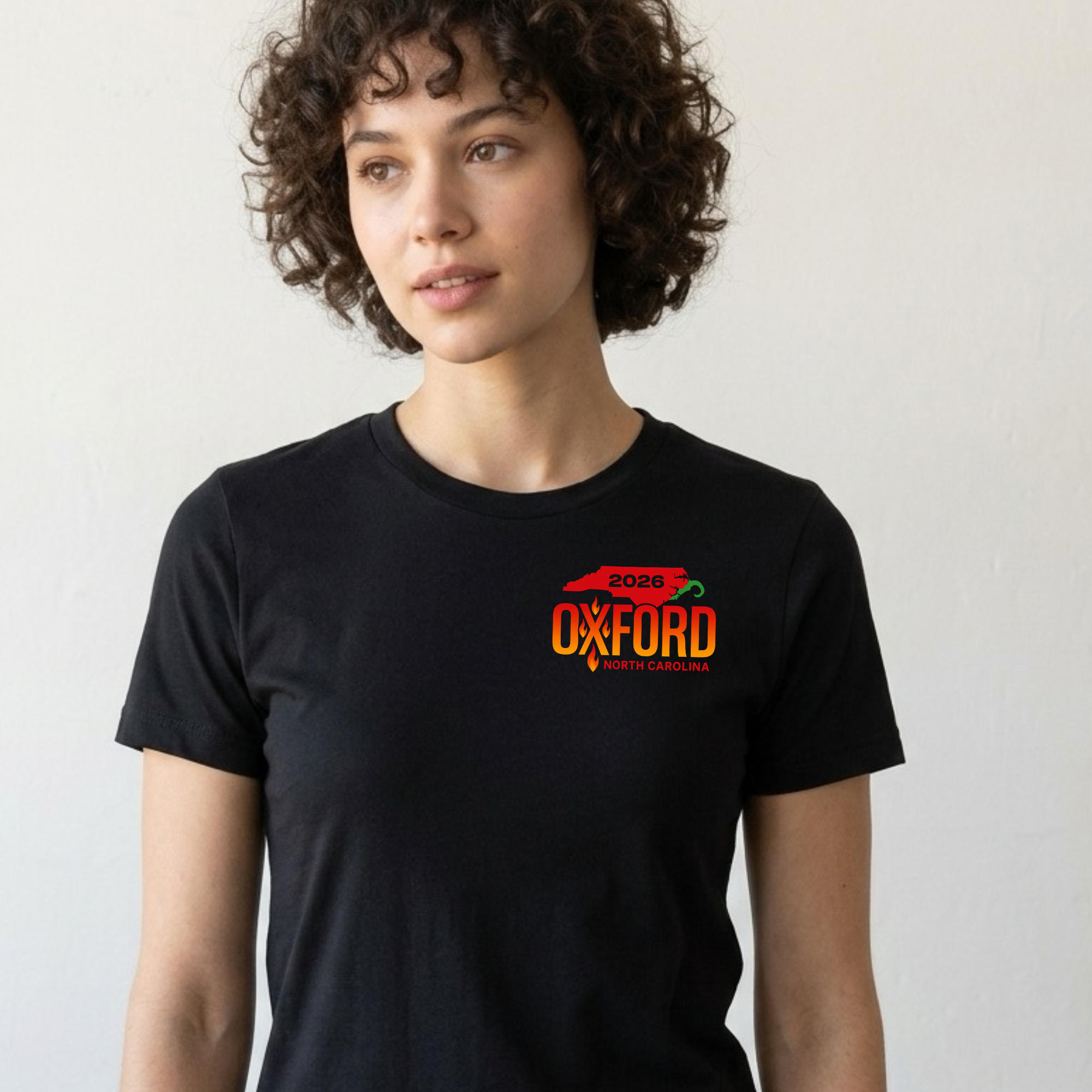 Gray T-shirt featuring NC Hot Sauce Festival design by Winks Design Studio, LLC, with colorful hot sauce bottle graphic.