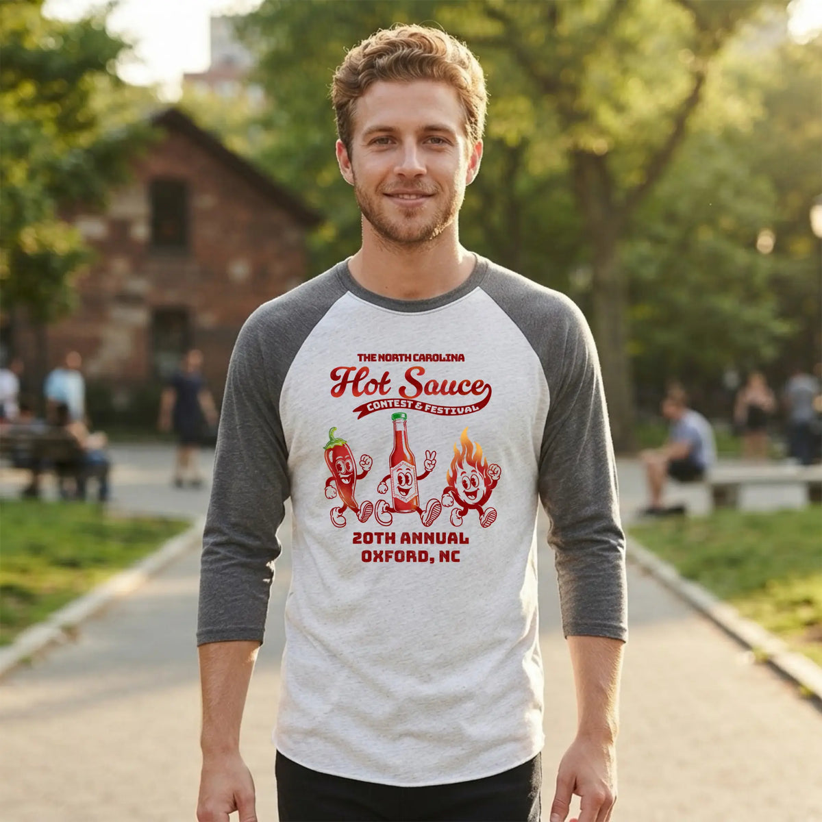 Winks Design Studio NC Hot Sauce Festival retro character raglan shirt featuring colorful vintage-style graphic on front.