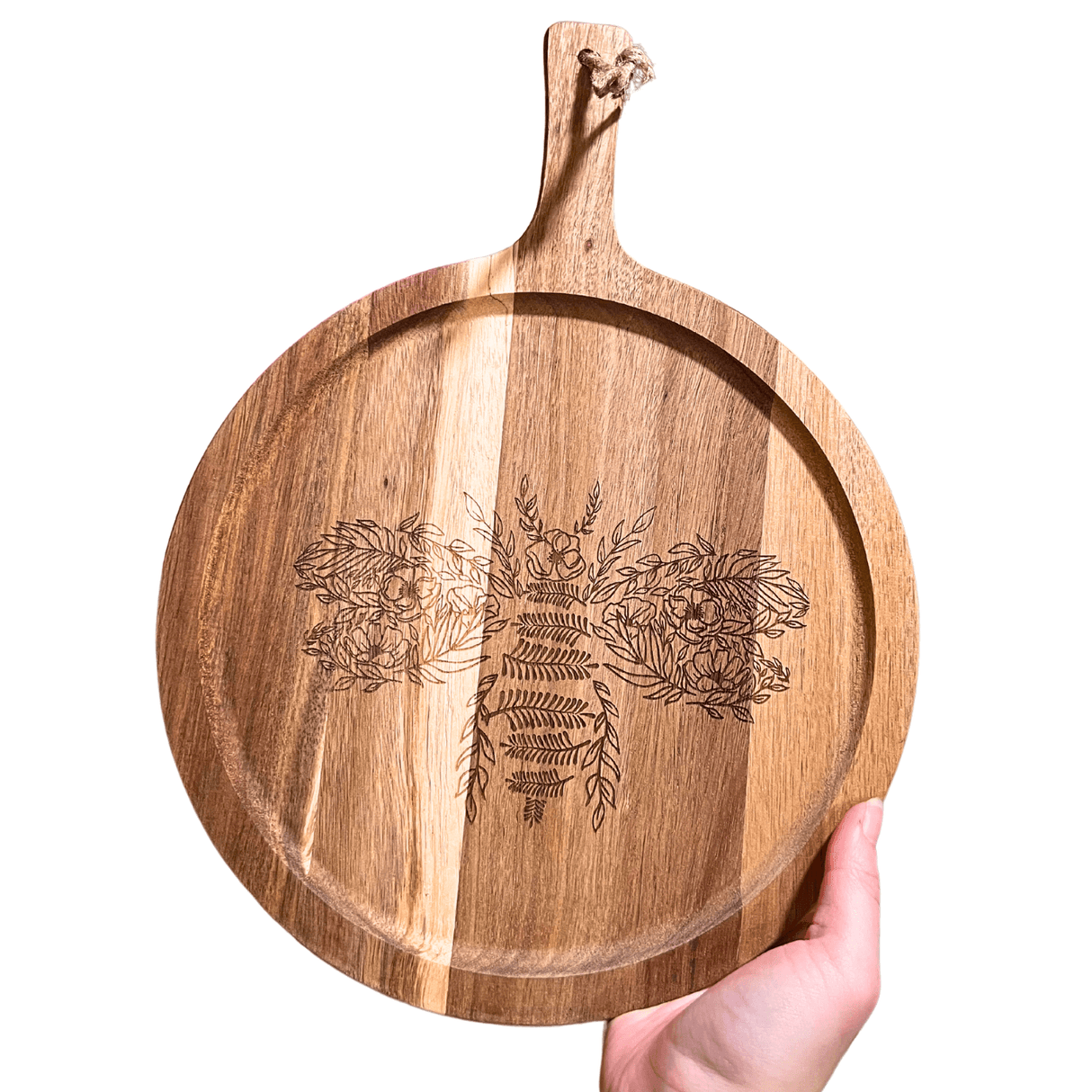 Flower Bee Charcuterie Board made of acacia wood, featuring elegant bee and floral engravings, held in a hand