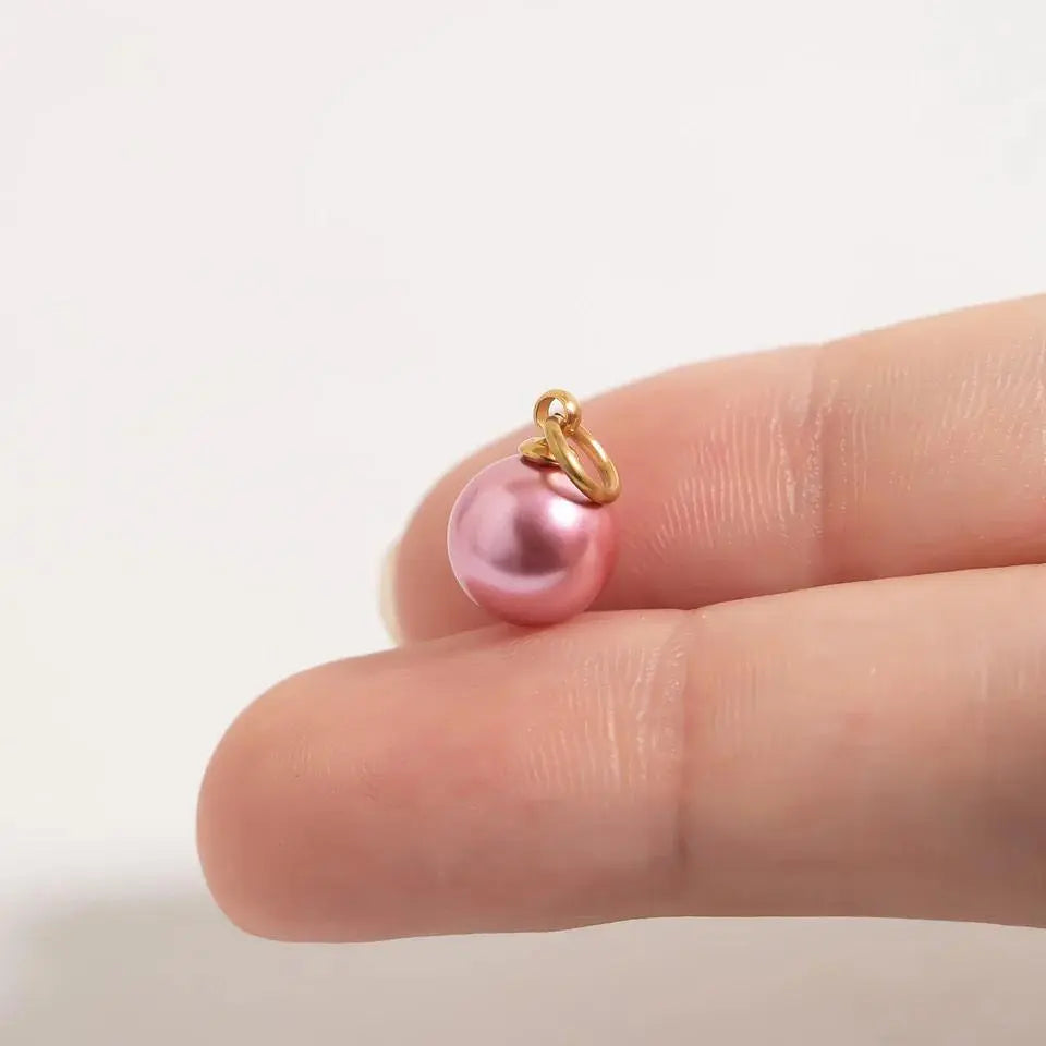 18K gold pink pearl charm by Winks Design Studio, LLC featuring a delicate pink pearl and intricate gold detailing.
