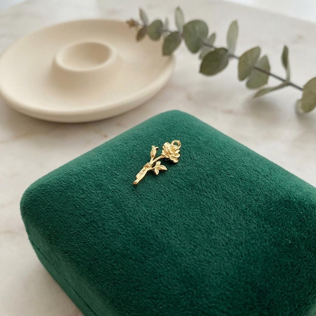 Gold rose flower charm jewelry from Winks Design Studio, LLC featuring a detailed rose blossom pendant.