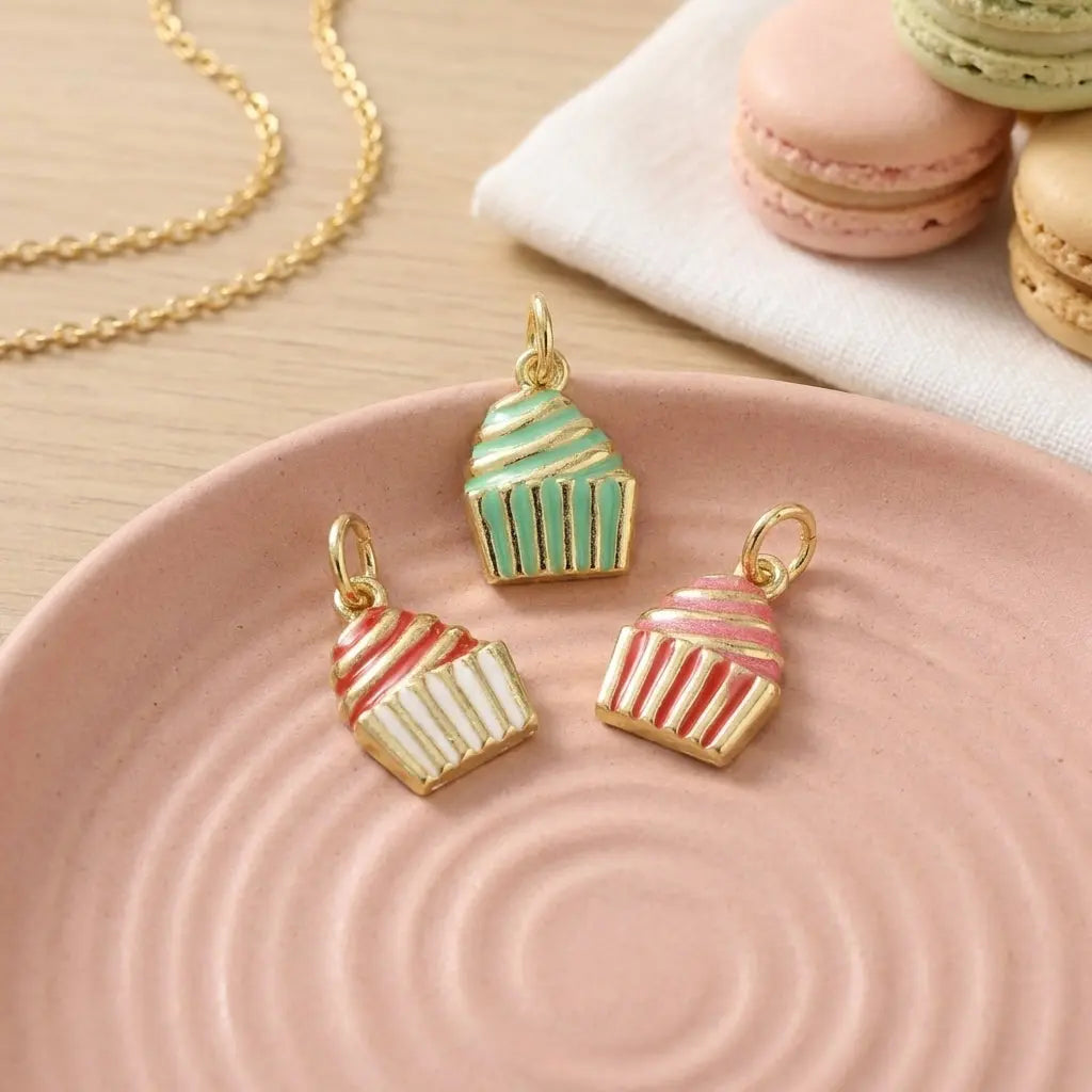Gold frosted cupcake charm from Winks Design Studio, LLC, featuring intricate detailing and a shiny gold finish.
