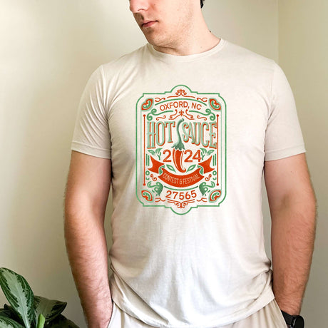 Vintage NC Hot Sauce Contest & Festival T-shirt on man, featuring colorful retro label design, made from soft premium cotton blend.