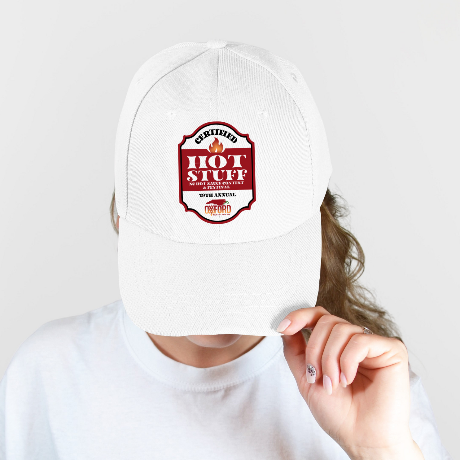 Person wearing a white cap with a &