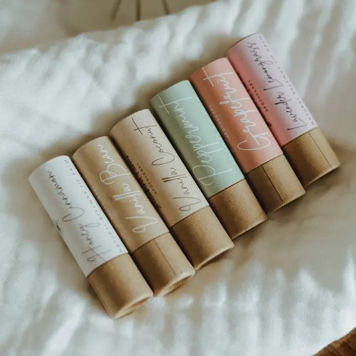Natural beeswax lip balm by Winks Design Studio, LLC, showing a smooth, cylindrical container with a clear label and golden beeswax balm inside.