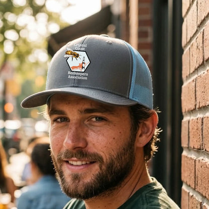 Winks Design Studio LLC Crystal Coast Beekeepers Richardson trucker hat with mesh back and embroidered logo on front.