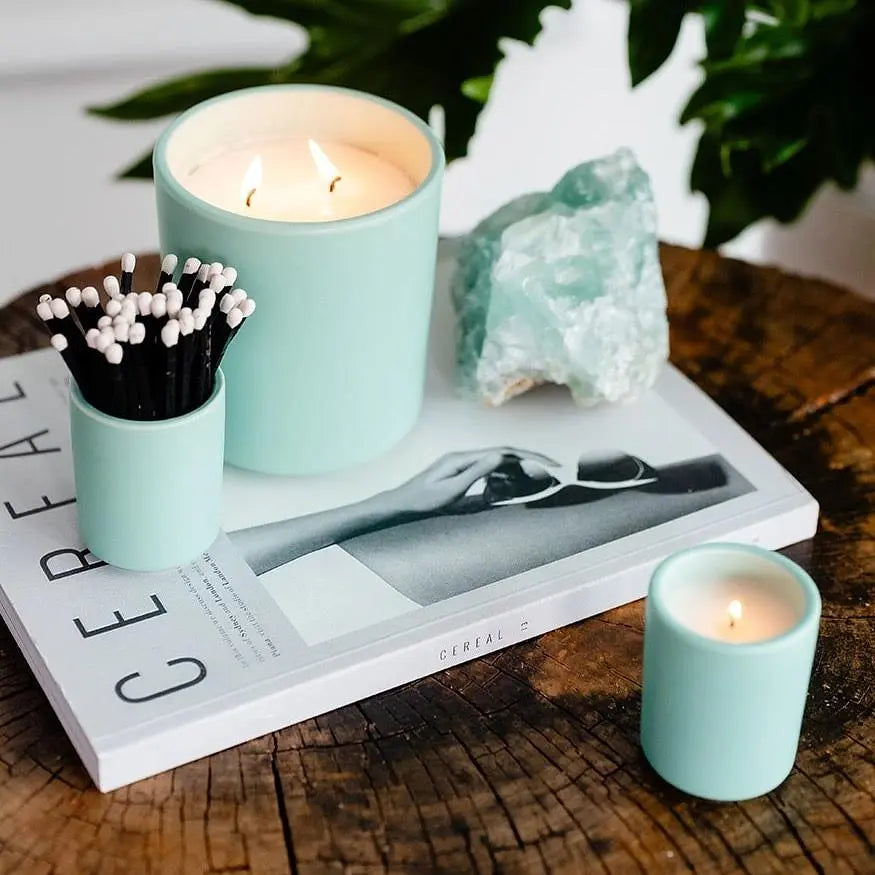 Earth &amp; Ember 13 oz candle by Winks Design Studio, LLC, featuring a textured glass container and a white wax candle inside.