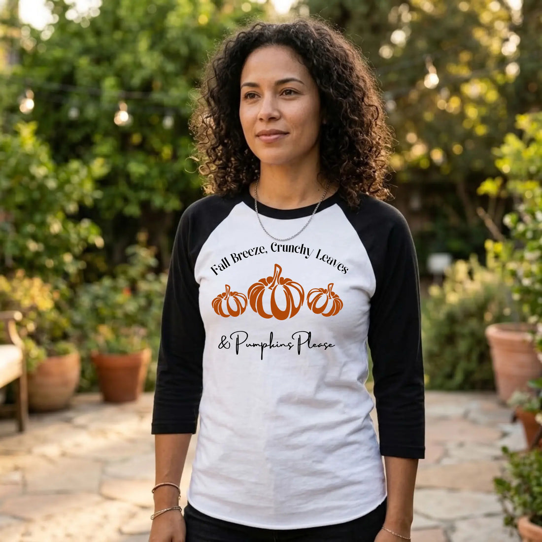 Woman in a white and black "Fall Breeze, Crunchy Leaves &amp; Pumpkins Please" raglan tee on a garden patio