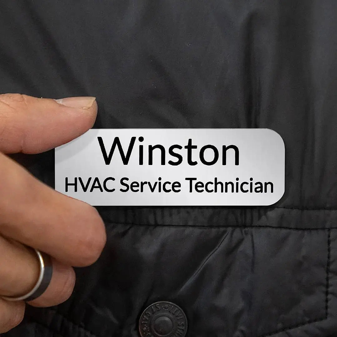 Custom engraved magnetic name badge by Winks Design Studio, LLC, showing a sleek metal badge with personalized engraved text.