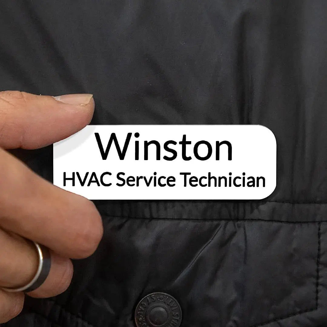 Custom engraved magnetic name badge from Winks Design Studio, LLC with a sleek design and personalized text on a professional badge.