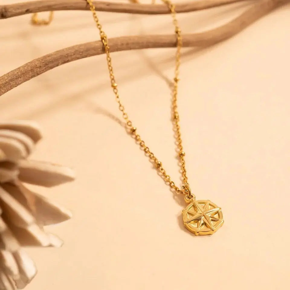 18K gold compass charm jewelry by Winks Design Studio, LLC, featuring a detailed nautical-inspired design.