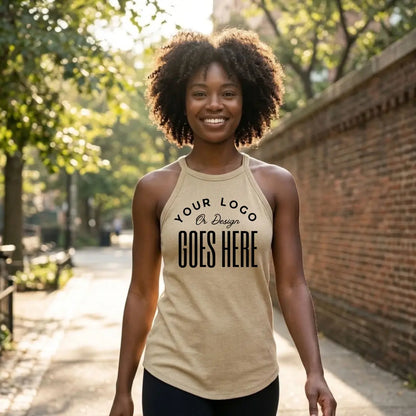 Smiling woman in a tan custom high neck tank top with black leggings on a sunny, tree-lined sidewalk