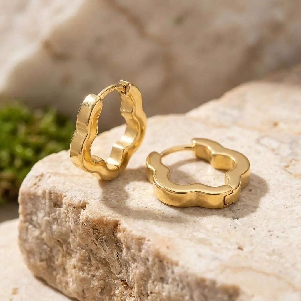 18K gold flower-shaped huggie earrings by Winks Design Studio, LLC, featuring delicate floral design and small hoop style.