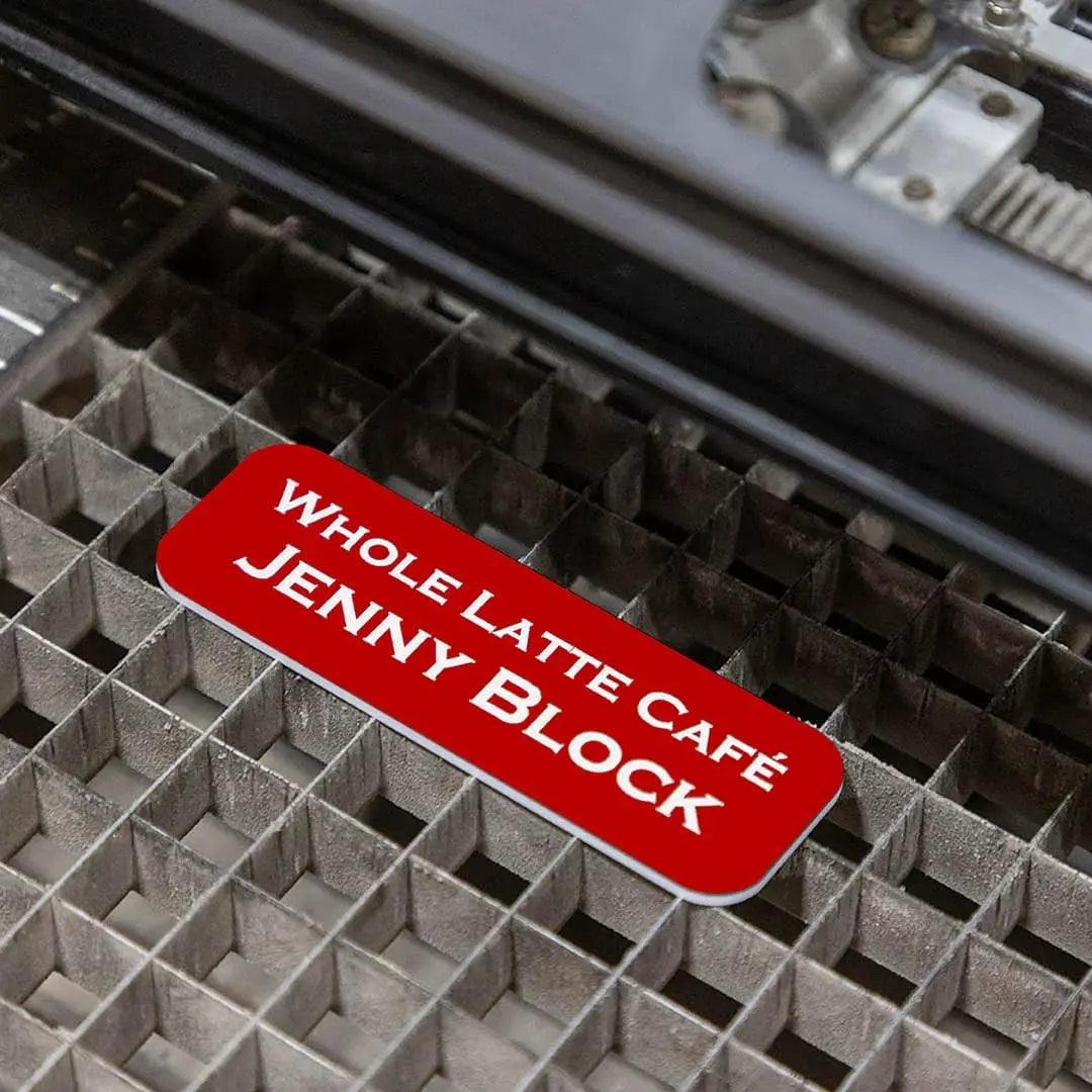 Custom engraved magnetic name badge by Winks Design Studio showing a sleek metal badge with personalized text and magnetic backing