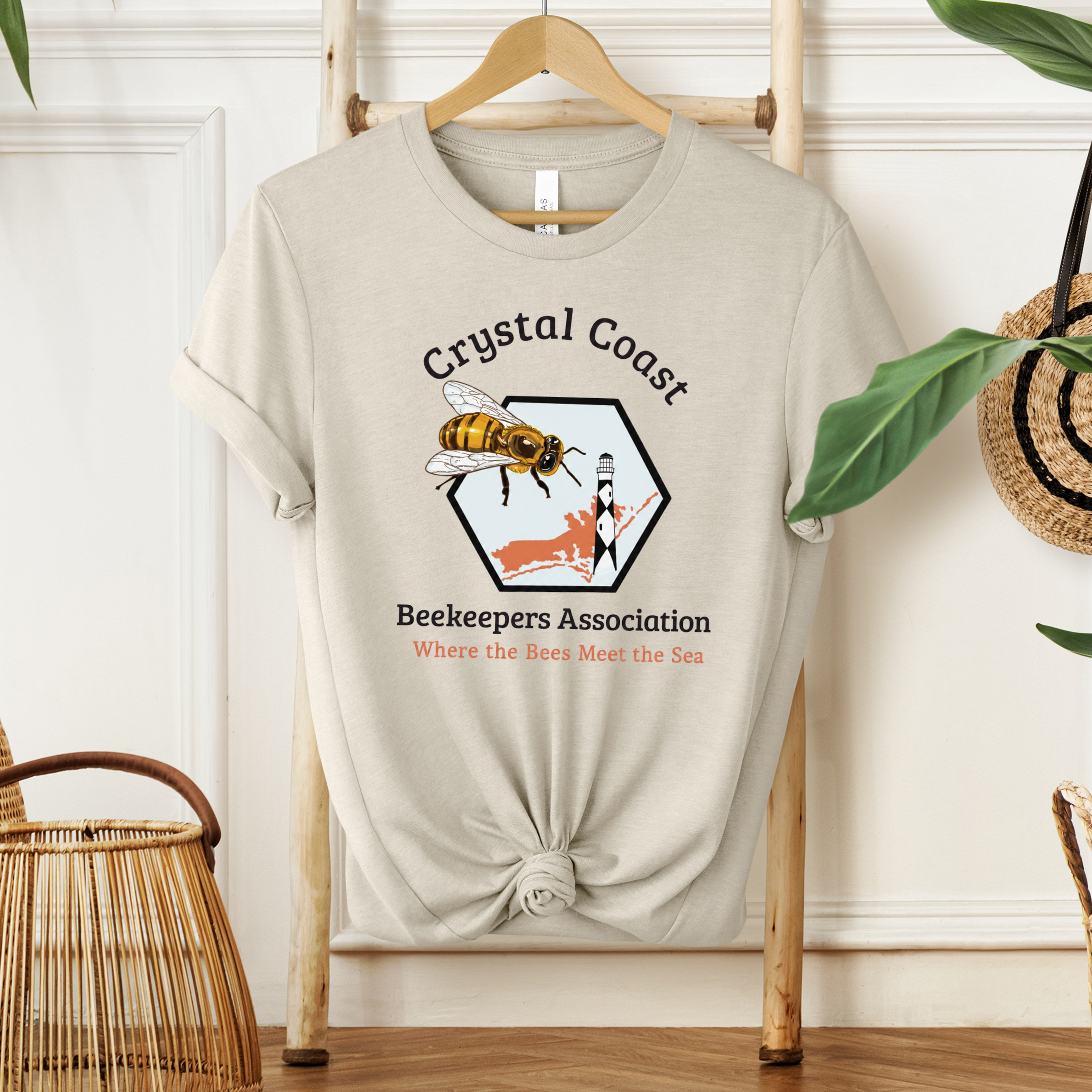 Winks Design Studio Crystal Coast Beekeepers T-shirt featuring a colorful bee and honeycomb design on soft cotton fabric.