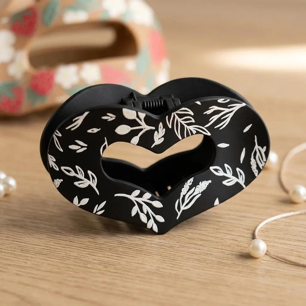 Winks Design Studio Sage and Stem Heart Claw Clip holding hair, featuring a decorative heart-shaped design and natural sage green color.