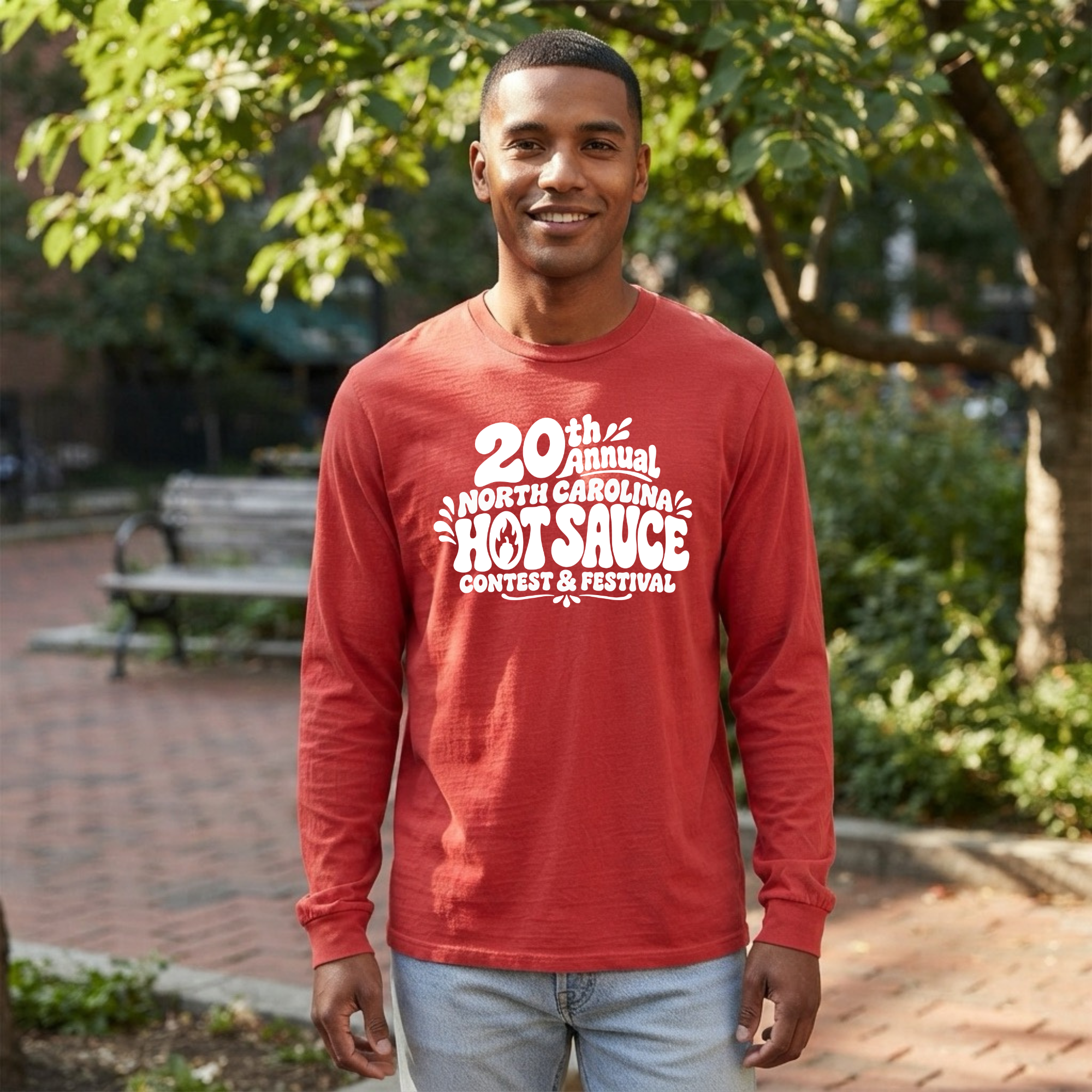 A man wearing a red long-sleeve t-shirt with a white graphic print that reads &