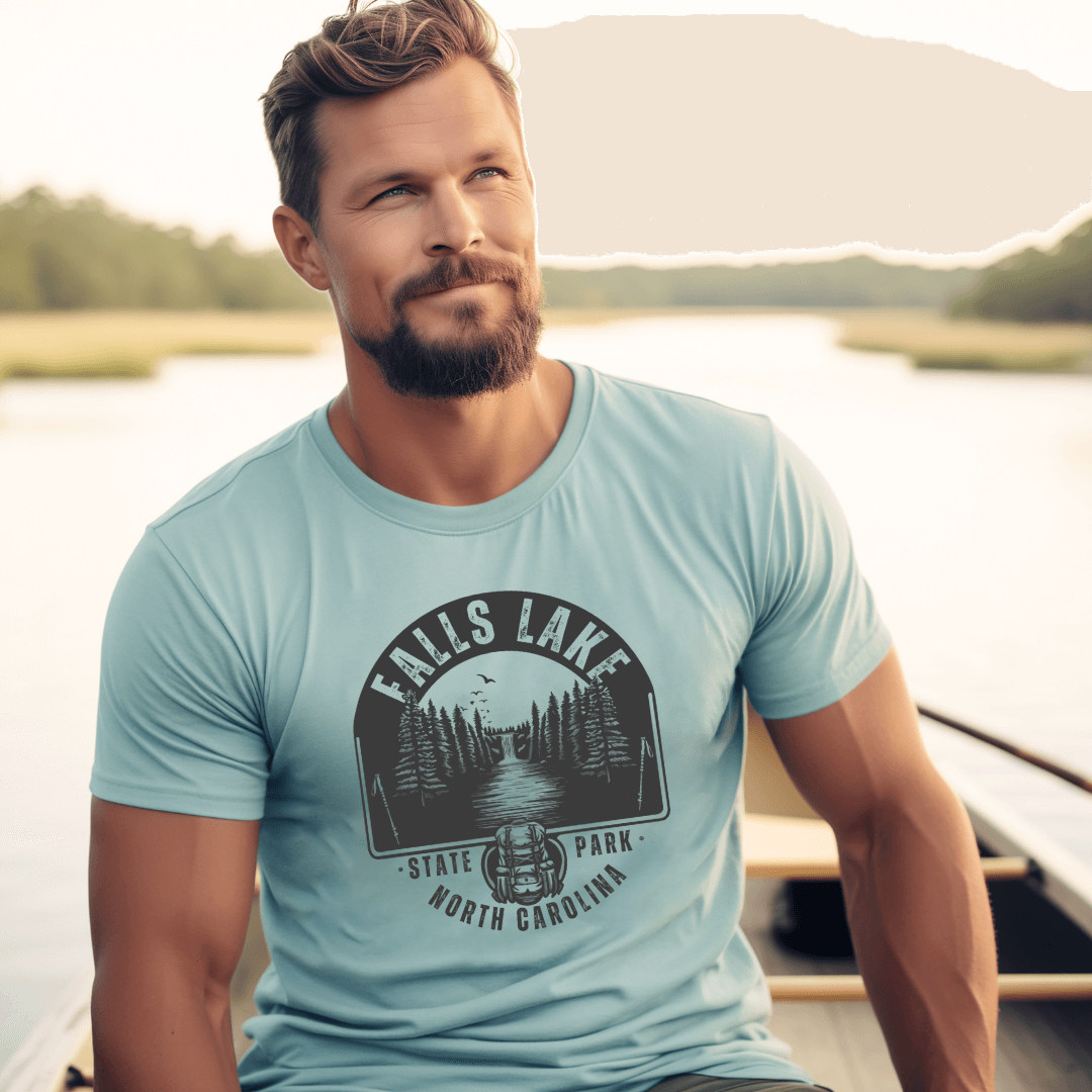 Man wearing Falls Lake T-shirt on a boat, enjoying scenic North Carolina nature and outdoor adventure.