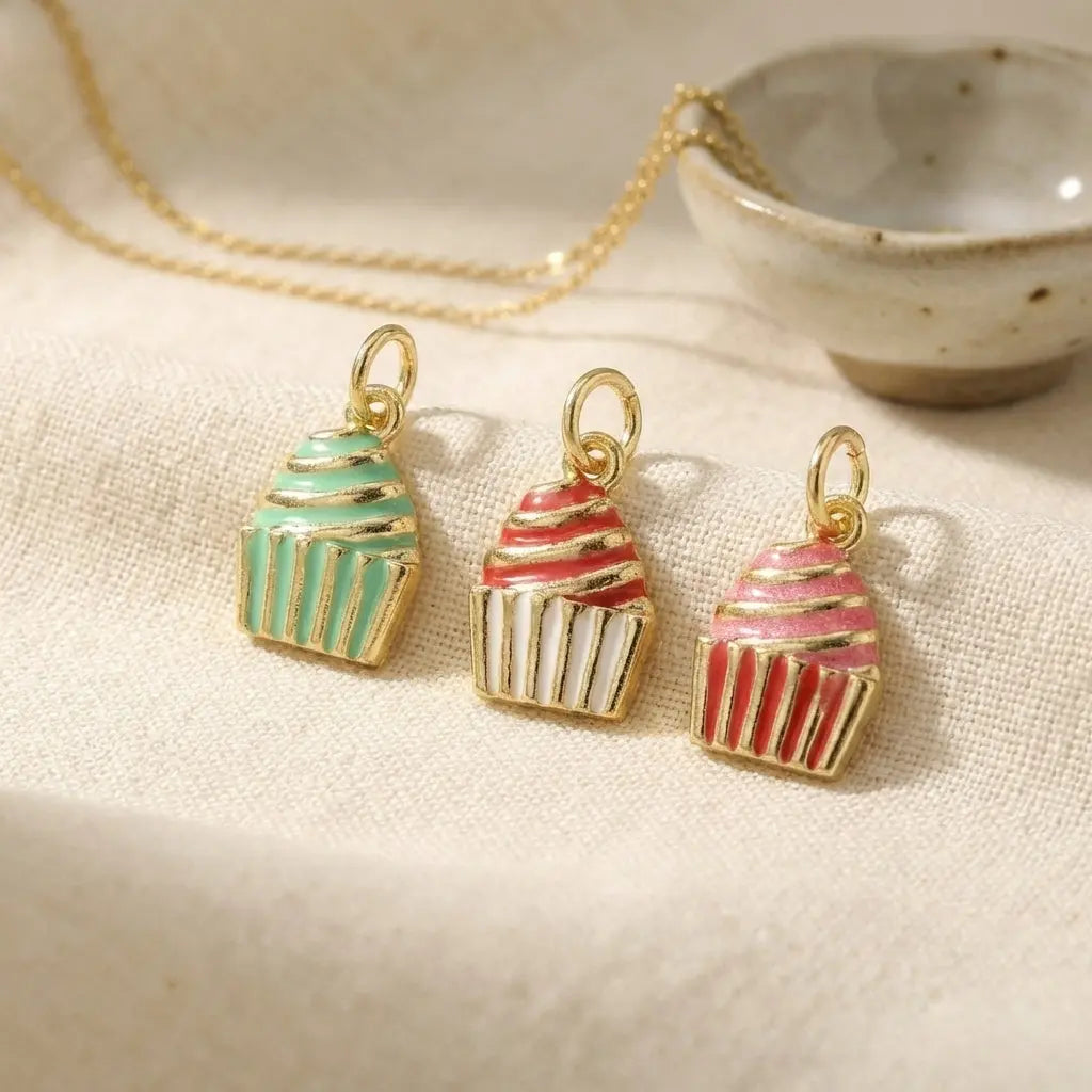 Gold frosted cupcake charm by Winks Design Studio, LLC, featuring a detailed cupcake design with a shiny gold finish.