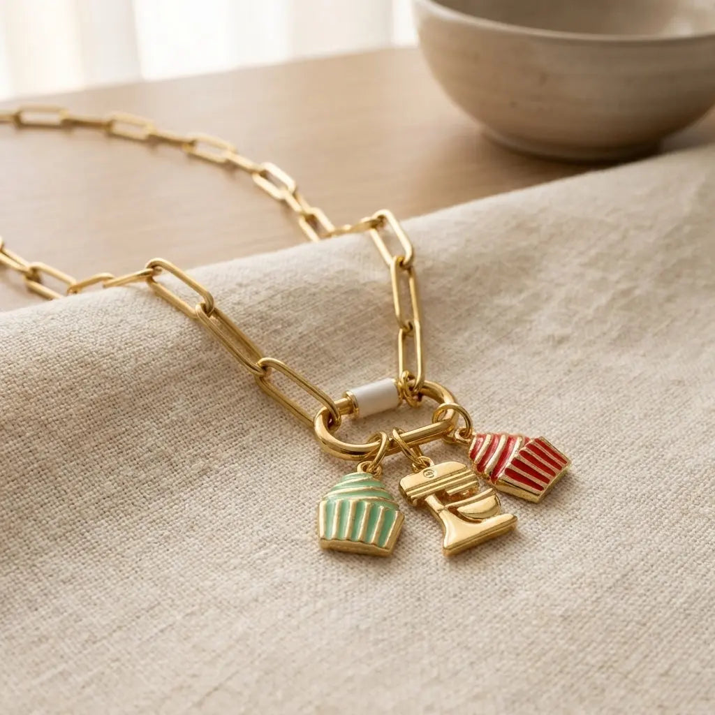 Gold frosted cupcake charm by Winks Design Studio, LLC, featuring a detailed cupcake with gold finish and textured frosting.