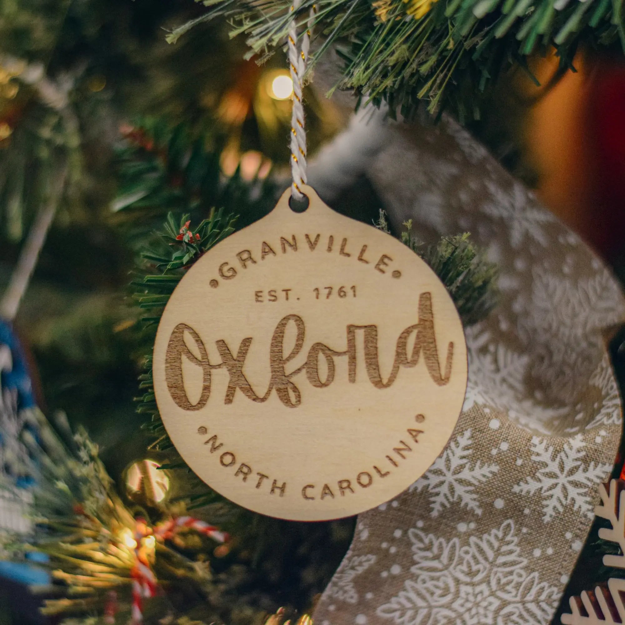 Winks Design Studio LLC Circular Oxford ornament with intricate design and detailed craftsmanship, perfect for decorative display.