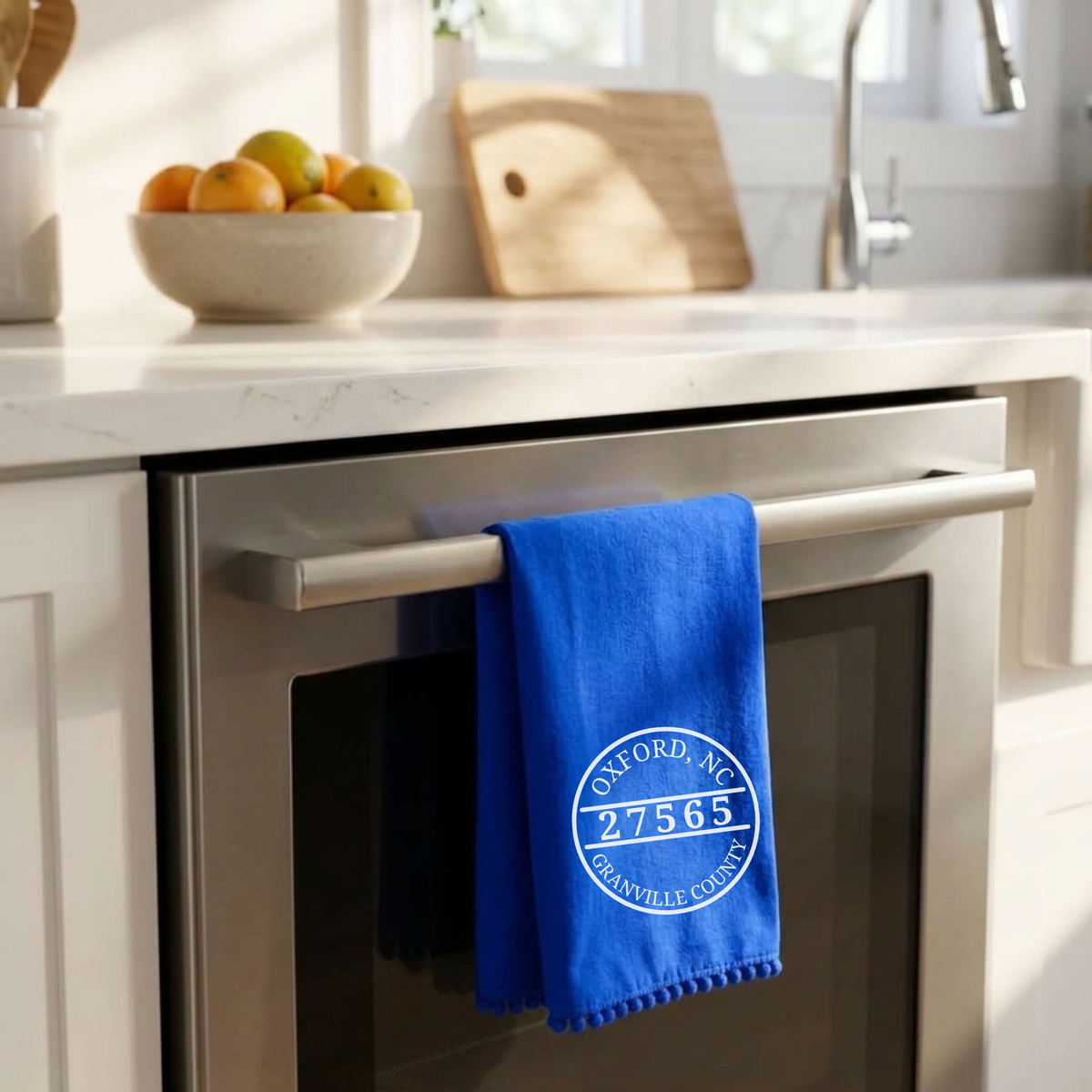 A bright blue kitchen towel with a white circular &