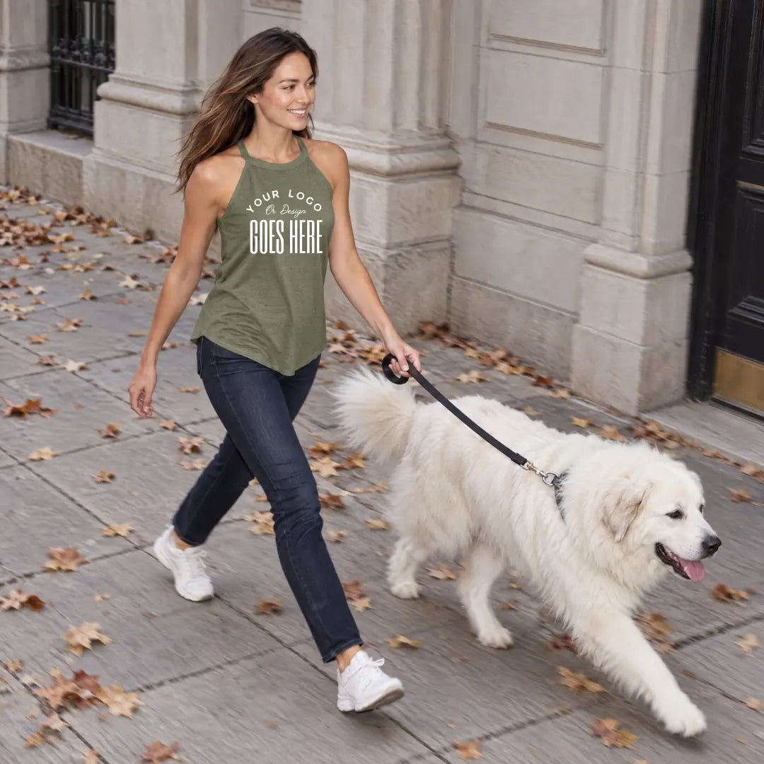Woman in a heather olive custom high neck tank top walking a large white dog on a city sidewalk