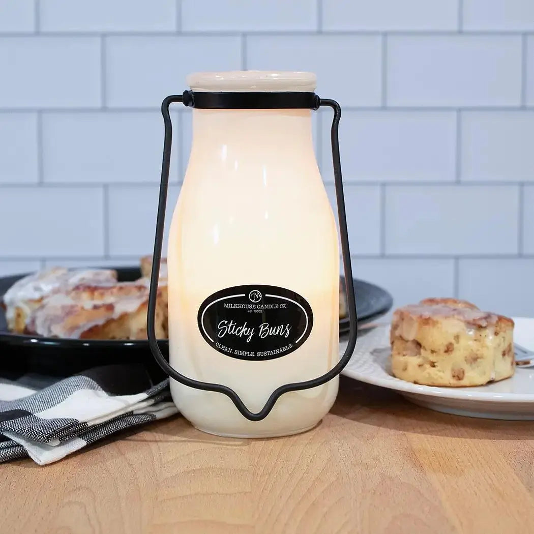 Winks Design Studio LLC Milkhouse Candle 14oz Sticky Buns scented candle with a warm, inviting appearance and a textured surface.